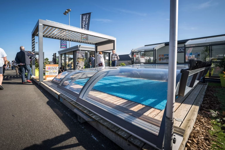 Stand extérieur à la Foire du Mans, présentant des abris de piscine et pergolas bioclimatiques.